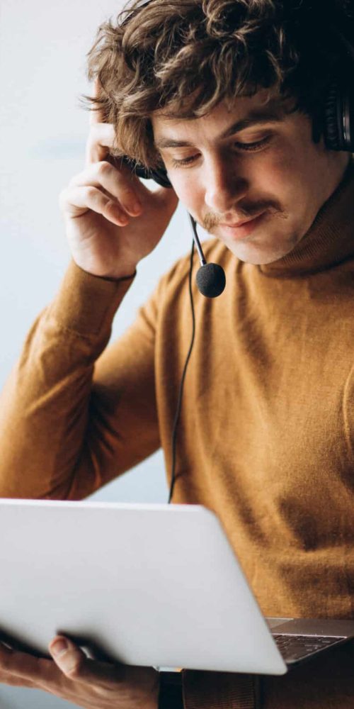 Young male interpreter working on laptop